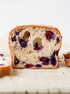 Blueberry Brioche recipe by Wood and Spoon blog. This is a recipe for two yeast loaves of brioche made with butter, egg, and a smidge of sugar. The fluffy white bread is studded with blueberries and seasoned with cinnamon. Each loaf has an optional crumble topping for extra sweet and salty in each bite. Learn how to fold and create this beautiful homemade breakfast treat here at thewoodandspoon.com by Kate Wood.