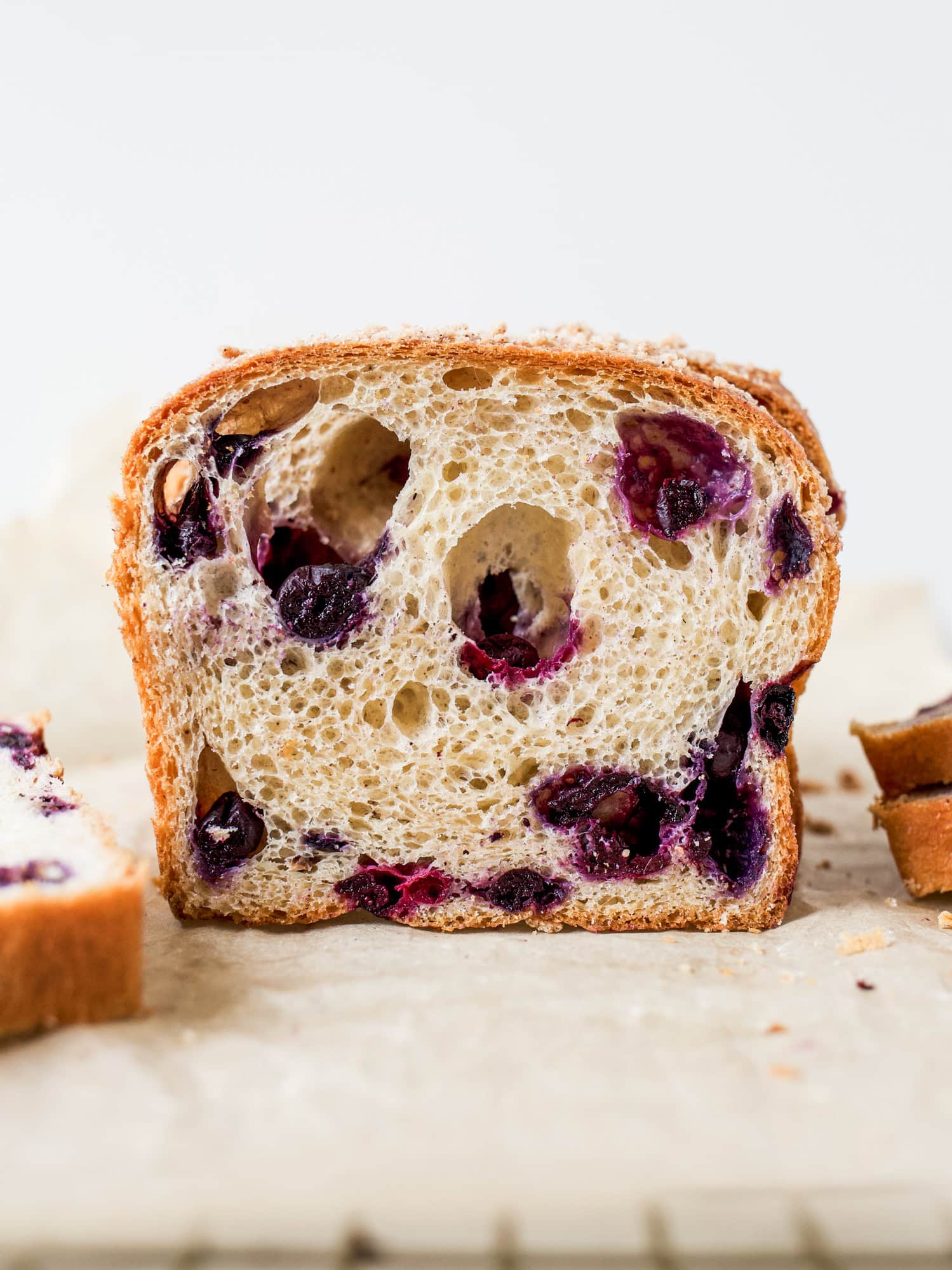 Blueberry Brioche recipe by Wood and Spoon blog. This is a recipe for two yeast loaves of brioche made with butter, egg, and a smidge of sugar. The fluffy white bread is studded with blueberries and seasoned with cinnamon. Each loaf has an optional crumble topping for extra sweet and salty in each bite. Learn how to fold and create this beautiful homemade breakfast treat here at thewoodandspoon.com by Kate Wood.