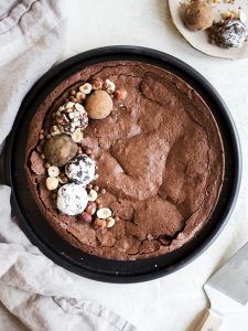 Flourless Chocolate Cake recipe by Wood and Spoon. This is a fudgy meringue cake flavored with espresso. It has a fallen sunken top from the egg whites and a flaky top with gooey center. Topped with cocoa powder, powdered sugar, or loads of decor, this cake is as beautiful as it is delicious. Perfect for the ultra rich chocolate lover in your life or for valentines day! Find the recipe and how to on thewoodandspoon.com