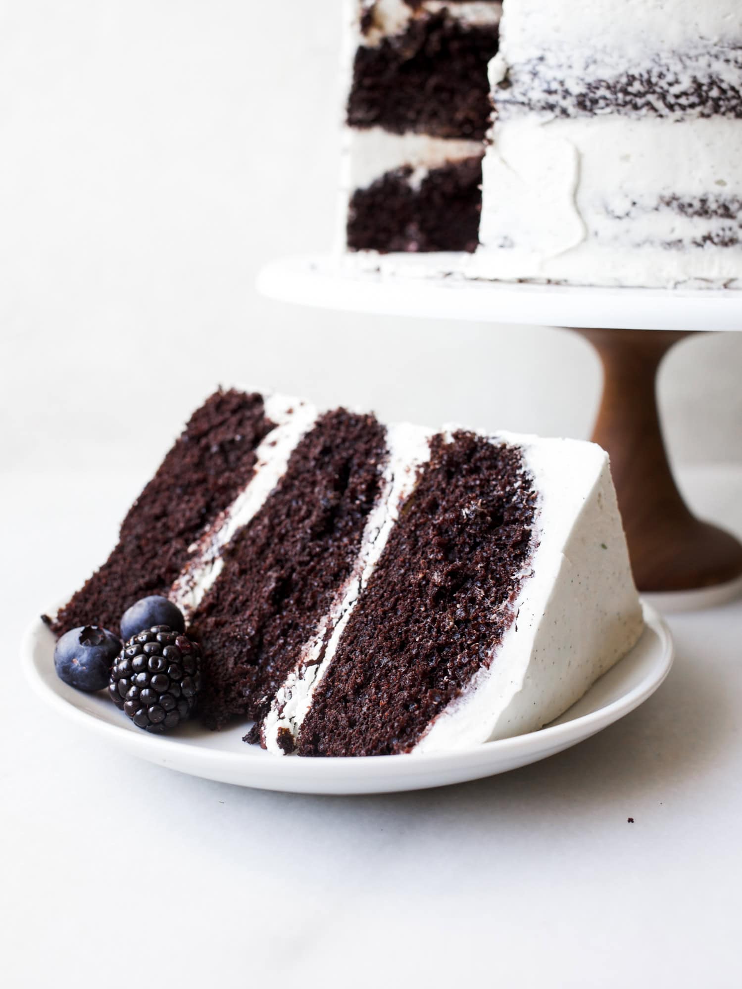 Black and White Cake By Wood and Spoon Blog by Kate Wood. This is a dark chocolate cocoa powder cake, made in one bowl, layered with a cooked flour vanilla bean frosting and a blackberry and dark chocolate ganache. This is a layer cake that is stunning and can even be used as a party/ wedding cake. The berry ganache is made with jam and cream. The cake is moist and fluffy, incredibly simple, and the frosting and smooth, light, and creamy cloud like. Find the recipe and the how to on thewoodandspoon.com
