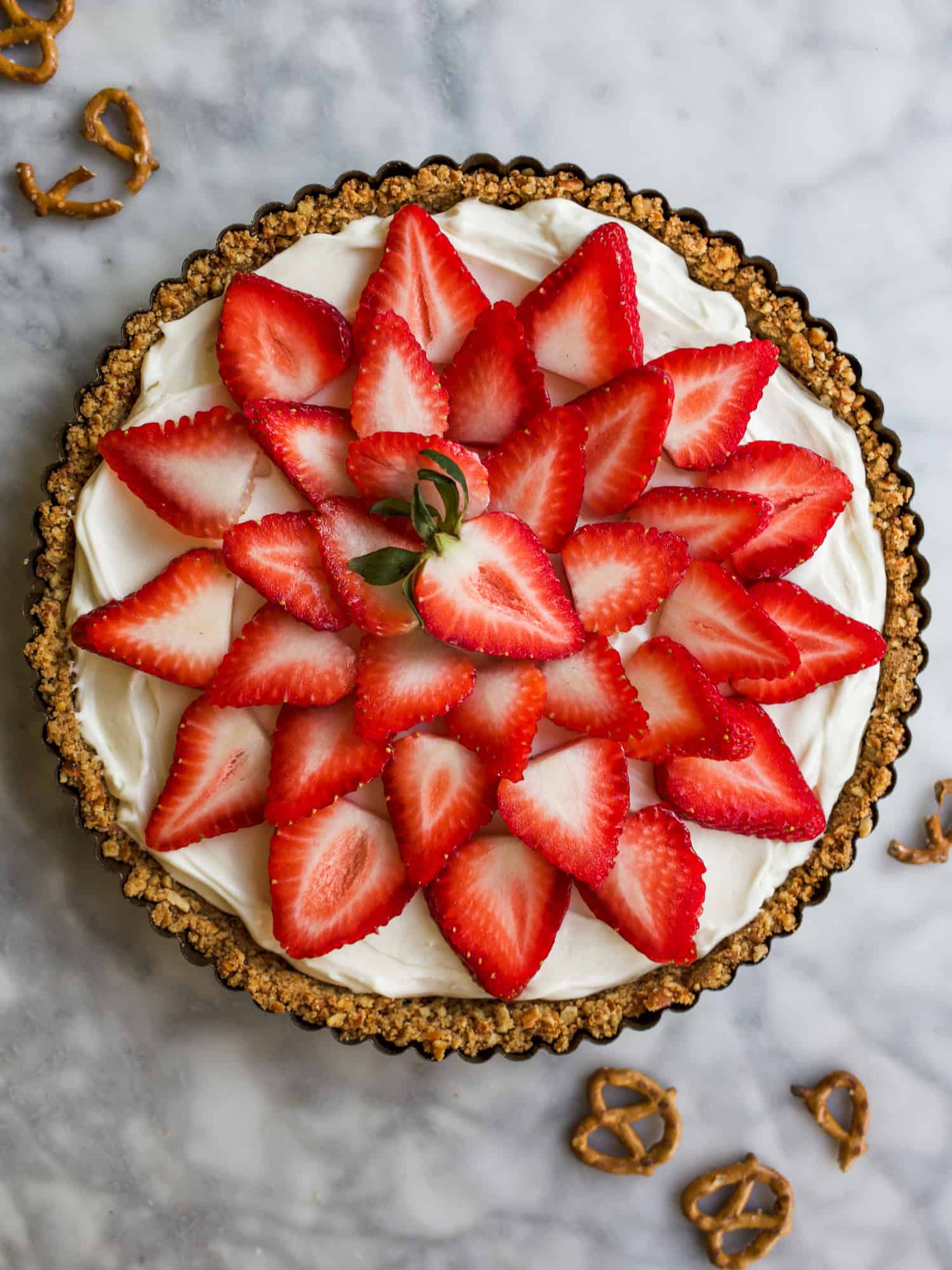 Strawberry Pretzel Tart Recipe by The Wood and Spoon Blog by Kate Wood. A simple, fast recipe that takes less than 30 minutes. A quick brown sugar butter and pretzel pie crust filled with a no bake cream cheese cheesecake type filling and topped with fresh strawberries or berries of your choice. Recipe adapted from Bake from Scratch Magazine. Perfect make ahead dessert idea. Thewoodandspoon.com